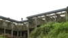 People walk on an abandoned public building in Buea, Cameroon, Aug. 1, 2019. (Moki Kindzeka/VOA) 