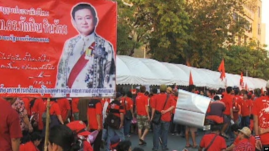 One red-shirted protester in Thailand holds a picture of former Prime Minister Thaksin Shinawatra, who was ousted in a coup in 2006