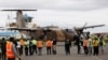 A Kenyan military aircraft carrying some of the bodies of those killed in the Mandera quarry attack, arrives at Wilson Airport in Nairobi, Kenya,Tuesday, Dec. 2, 2014.