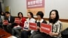 台湾人权活动人士李明哲的妻子李净瑜(中)与其他台湾民主运动活动者举着李明哲的照片(2017年3月24日)