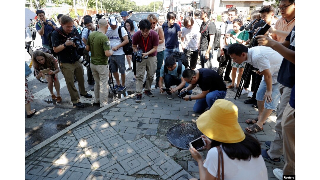 Reporters take pictures at the site of a blast outside the U.S. embassy in Beijing, China, July 26, 2018.