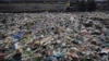 FILE - A man walks on the shores the Arabian Sea, littered with plastic and other garbage in Mumbai, India, June 4, 2018. The theme for that year's World Environment Day, marked on June 5, is "Beat Plastic Pollution." 