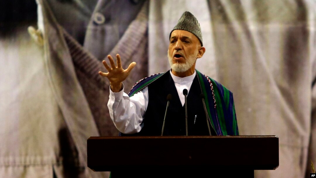 Afghan President Hamid Karzai, center, speaks during a ceremony honoring the late Commander Ahmad Shah Massoud, a beloved anti-Taliban fighter who was assassinated 13 years ago, in Kabul, Afghanistan, Sept. 9, 2014. 