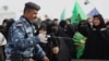 An Iraqi policeman uses a bomb detector to search Shi'ite pilgrims heading to the Shi'ite holy city of Karbala, 80 kilometers (50 miles) south of Baghdad, Iraq, Dec. 10, 2014. 