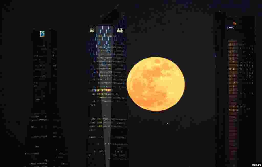 A full moon "supermoon" rises in between four towers in a skyscrapers area in Madrid, Spain, Jan. 31, 2018.