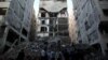 Palestinians gather near the remains of a building that was destroyed by an Israeli airstrike, in Gaza City, Nov. 13, 2018.