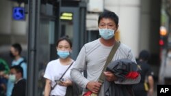 People wear face masks to protect against the coronavirus, in Taipei, Taiwan, Feb. 26, 2020. 