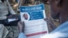 A man holds a flyer printed by the International Criminal Court (ICC) explaining the trial of LRA commander Dominic Ongwen, in Lukodi, Uganda, Feb. 4, 2021.