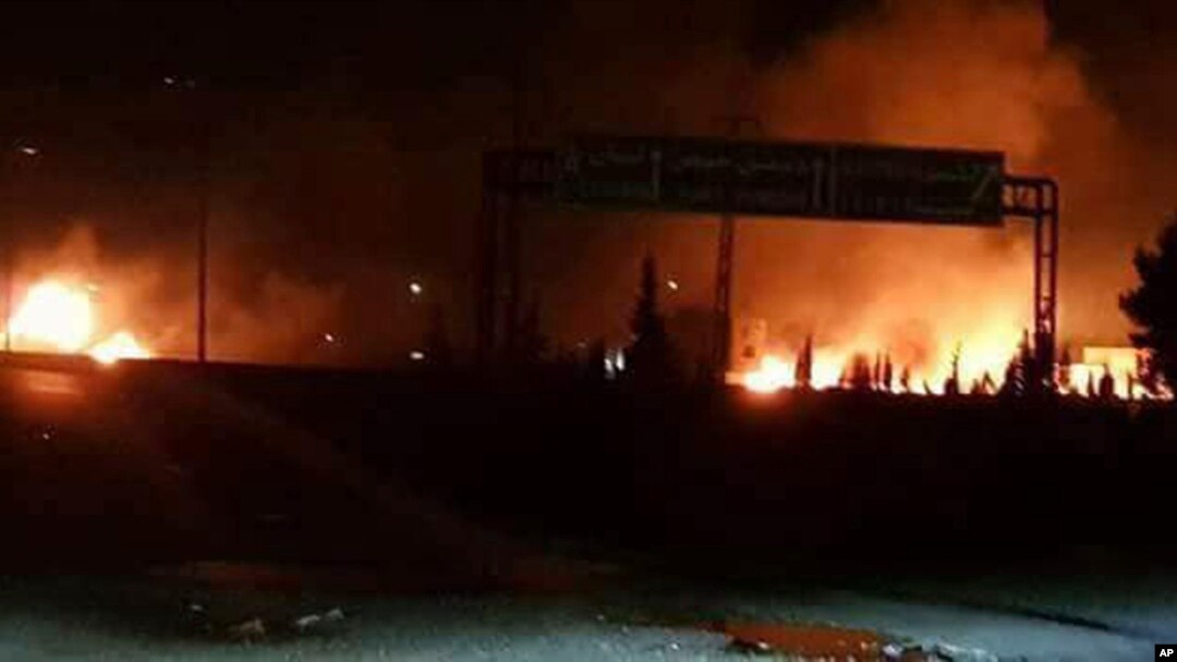 FILE - This photo released May 9, 2018, by the Syrian official news agency SANA, shows flames rising after an attack in an area known to have numerous Syrian army military bases, in Kisweh, south of Damascus, Syria.
