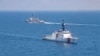 美国海军公布的图片显示美国海军“基德”号阿利·伯克级导弹驱逐舰与美国海岸警卫队“蒙罗”号传奇级巡逻舰在当地时间2021年8月27日例行穿越台湾海峡的国际水域。