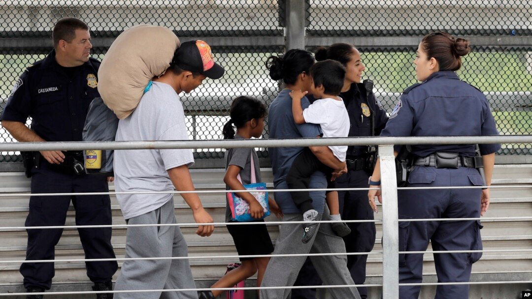 FILE - Ever Castillo (L) and his family, immigrants from Honduras, are escorted back across the border by U.S. Customs and Border Patrol agents, June 21, 2018, in Hildalgo, Texas.