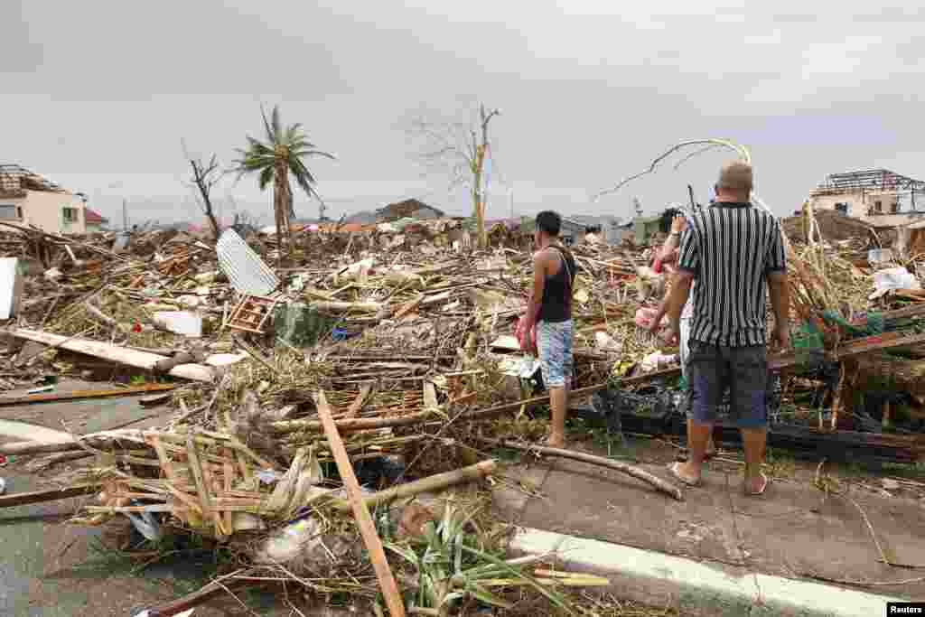 Survivors assess the damage after super Typhoon Haiyan battered Tacloban city, central Philippines, Nov. 9, 2013.