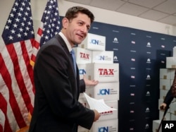 FILE - Speaker of the House Paul Ryan, R-Wis., points to boxes of petitions supporting the Republican tax reform bill, Washington, Nov. 14, 2017.