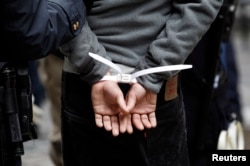 FILE - An Occupy Wall Street subject stands in plastic handcuffs after being arrested by New York police, Nov. 17, 2011.