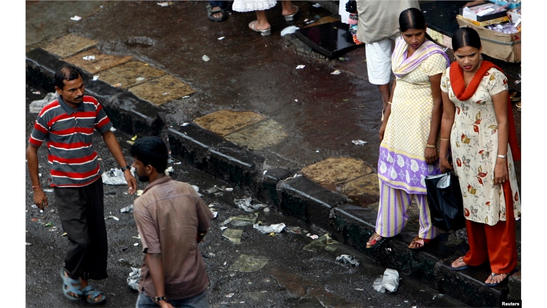 FILE - Two female sex workers stand on a roadside pavement for soliciting customers in a red-light area in Mumbai, July 28, 2007.