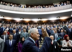 Turkey's Prime Minister Binali Yildirim greets members of parliament from his ruling AK Party as he arrives for a meeting at the Turkish parliament in Ankara, April 18, 2017.