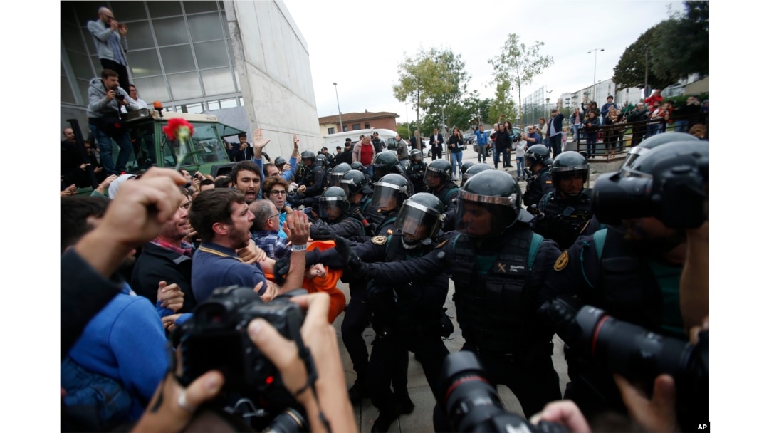 Civil guards clear people away from the entrance of a sports center, assigned to be a polling station by the Catalan government and where Catalan President Carles Puigdemont is expected to vote, in Sant Julia de Ramis, near Girona, Spain, Oct. 1, 2017.