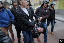 A rioter is taken away by police on a street at Mong Kok district of Hong Kong, Feb. 9, 2016.