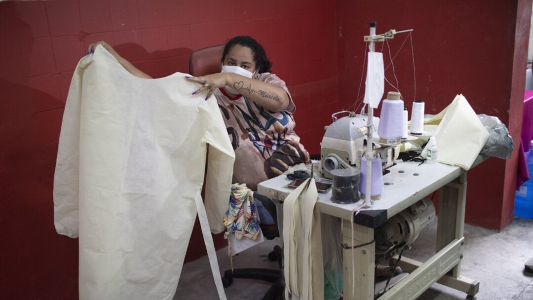 A worker from the Unidos de Padre Miguel samba school shows a medical scrub she is making in Rio de Janeiro, Brazil.