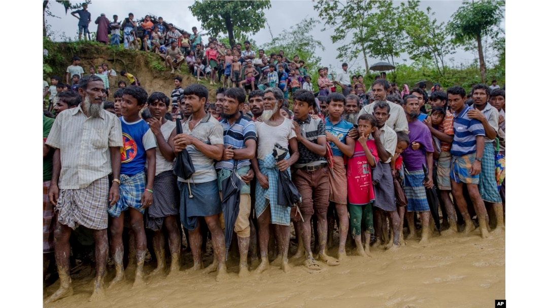 Rohingya Muslim men, who crossed over from Myanmar into Bangladesh, wait for their turn to collect food items distributed by aid agencies in Balukhali refugee camp, Bangladesh, Sept. 19, 2017.