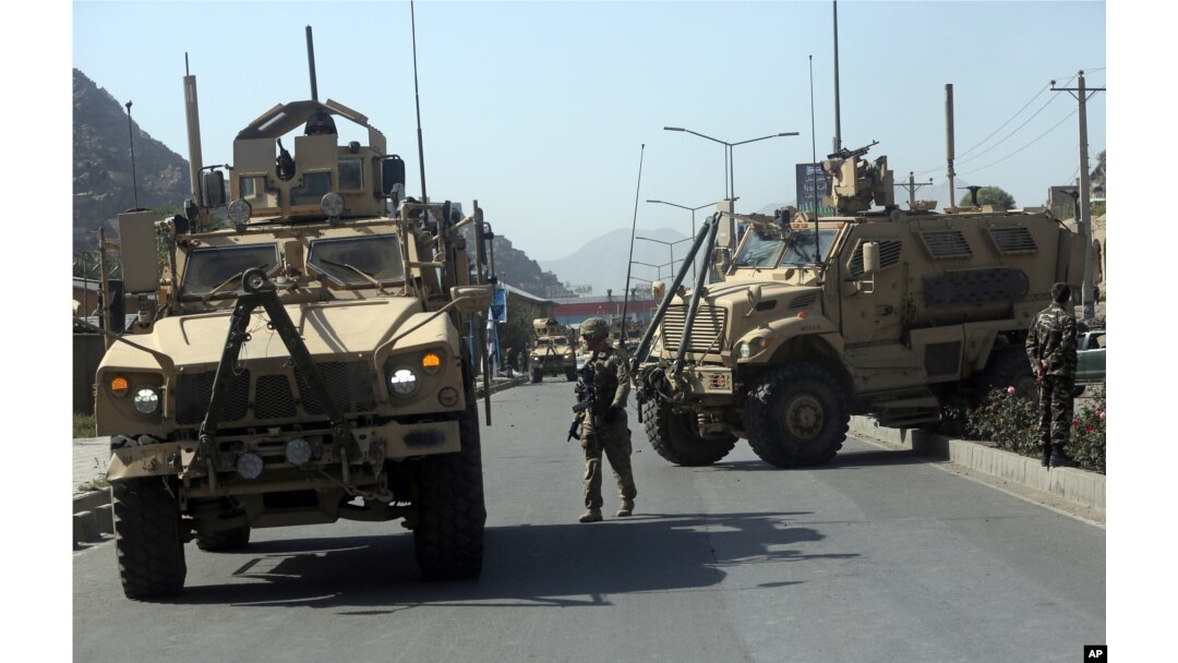 FILE - A U.S. soldier directs his colleagues at the site of a bomb attack that targeted several armored vehicles belonging to forces attached to the NATO Resolute Support Mission, in downtown of Kabul, Oct. 11, 2015.