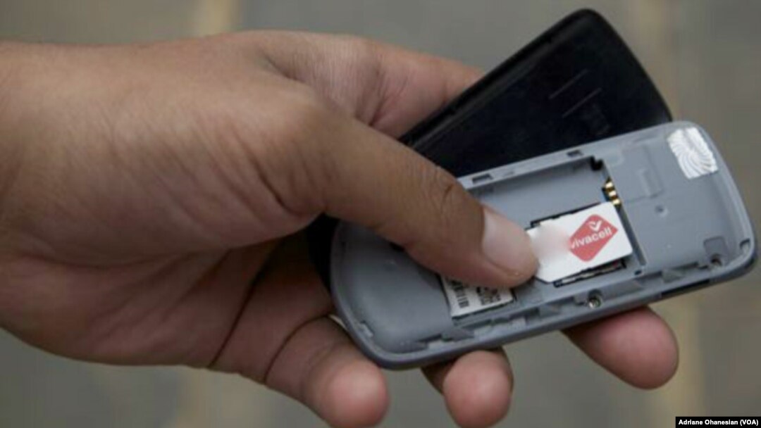 A mobile phone user in South Sudan checks his SIM card. 