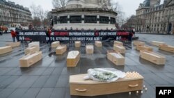 «Репортери без кордонів» (RSF) з 19 відкритими домовинами як символами 19 українських журналістів, ув’язнених у Росії, і однією закритою з квітами у пам'ять про журналістку Вікторію Рощину, Париж, 20 лютого 2025 року. GEOFFROY VAN DER HASSELT/AFP