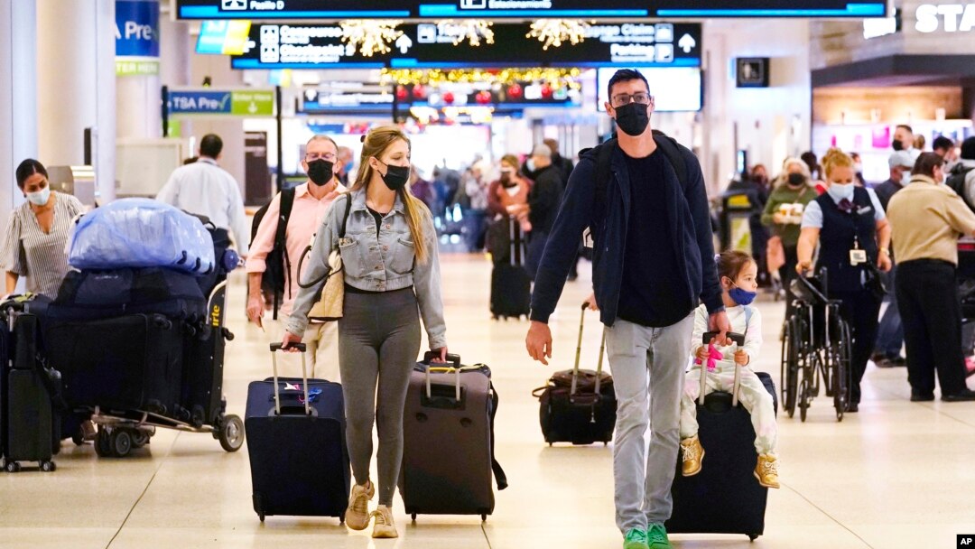 Holiday travelers push their luggage inside Miami International Airport, Tuesday, Nov. 23, 2021, in Miami. (AP Photo/Marta Lavandier)