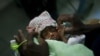 Three-day-old premature baby Jessica Thelusma is carried by her mother Silvie Estain in the emergency room at General Hospital in Port-au-Prince, Saturday, May 8, 2010. (AP Photo/Esteban Felix)