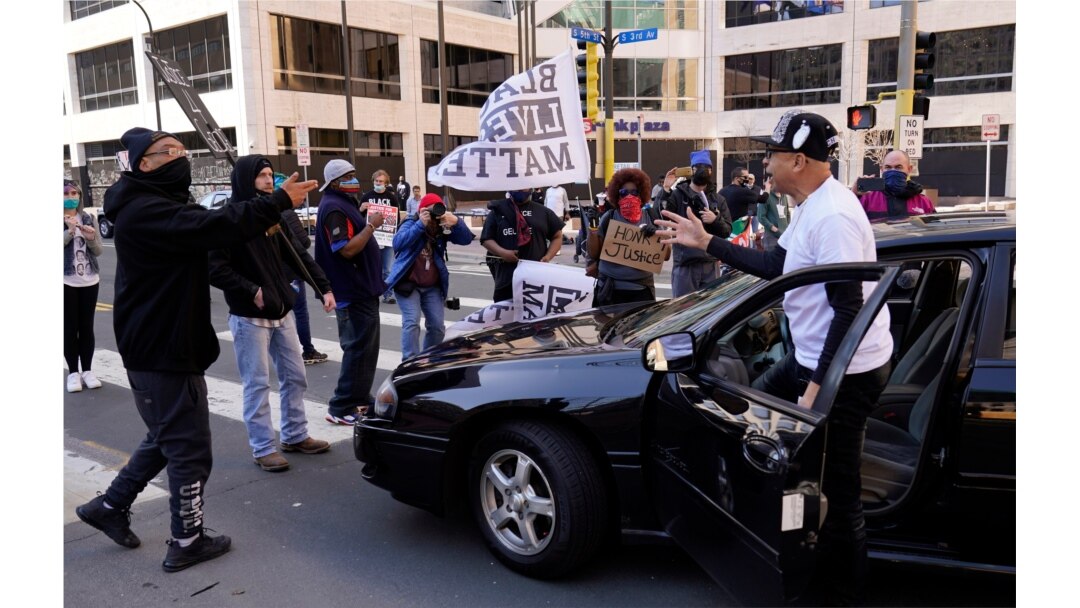 A motorist pleads to let him drive through on a street next to the Hennepin County Government Center as protesters held vehicles at bay until they honked their horns, March 29, 2021, in Minneapolis.