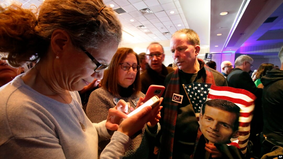 People check election returns on their phones at the election night party for Conor Lamb, the Democratic candidate for the March 13 special election in Pennsylvania's 18th Congressional District, on Canonsburg, Pa., Tuesday, March 13, 2018. (AP Photo)