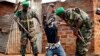 Rwandan African Union peacekeepers remove the lucky charms from a suspected Anti-Balaka Christian man who was found with a rifle and a grenade in a Muslim market in Bangui, Central African Republic on January 24. 