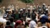 Followers of the Shi'ite Houthi movement stand in front of riot police near the cabinet building in Sanaa Sept. 9, 2014. 