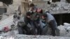 Syrians rescue a child following a reported government airstrike in the rebel-held town of Hamouria, in the besieged Eastern Ghouta region on the outskirts of the capital Damascus, Feb. 21, 2018. 