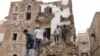 People stand on the debris of a house that recently collapsed due to heavy rains in the old quarter of Sanaa, Yemen May 3, 2020.