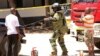 FILE - A member of a bomb disposal team prepares the scene before checking the bodies of three women who were shot dead by police, outside the central police station in the coastal city of Mombasa, Kenya, Sept. 11, 2016. 