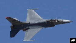 In this Feb. 24, 2019, file photo, U.S. fighter aircraft F-16 perform aerobatic maneuvers on the last day of Aero India 2019 at Yelahanka air base in Bangalore, India.