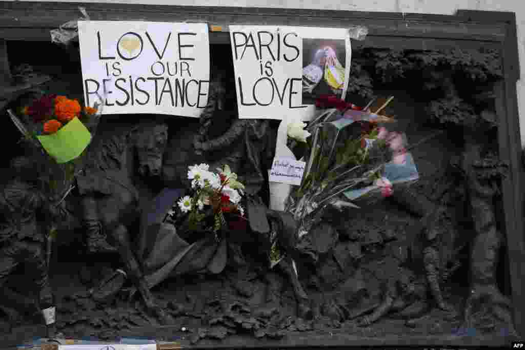 Signs reading 'Love is our resistance' and 'Paris is love' are pictured at the Monument a la Republique, at the Place de la Republique in Paris, on Nov. 15, 2015, two days after a series of deadly attacks.