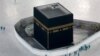 FILE - Workers disinfect the grounds around the Kaaba, a cubic building at the Grand Mosque in the Muslim holy city of Mecca, Saudi Arabia, March 7, 2020.