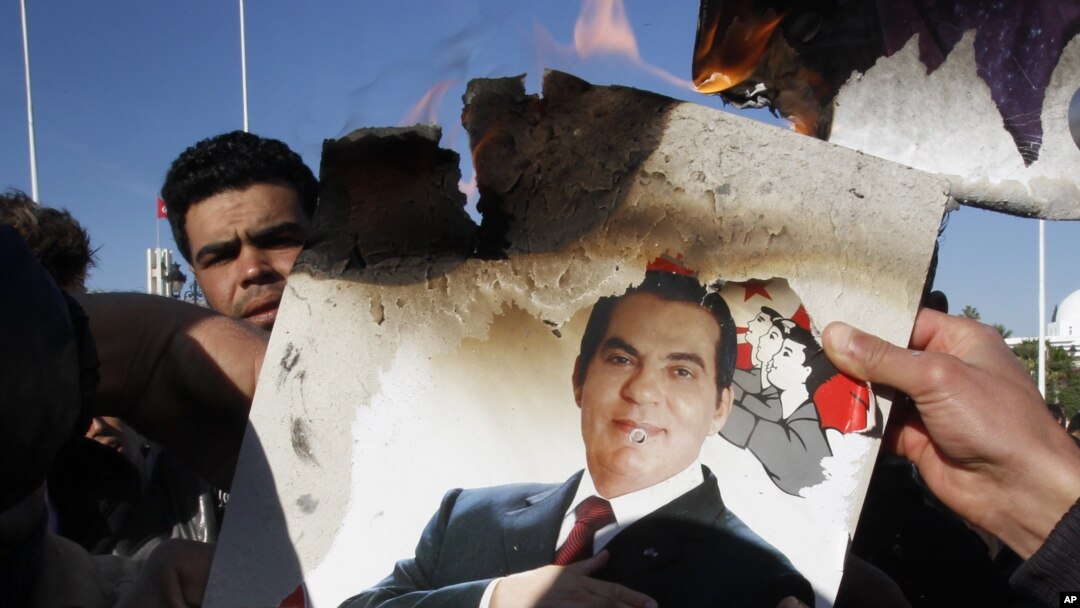  In this January 24, 2011 picture, protestors burn a photo of former Tunisian President Zine El Abidine Ben Ali during a demonstration against holdovers from Ben Ali's regime in the interim government in Tunis, Tunisia. 