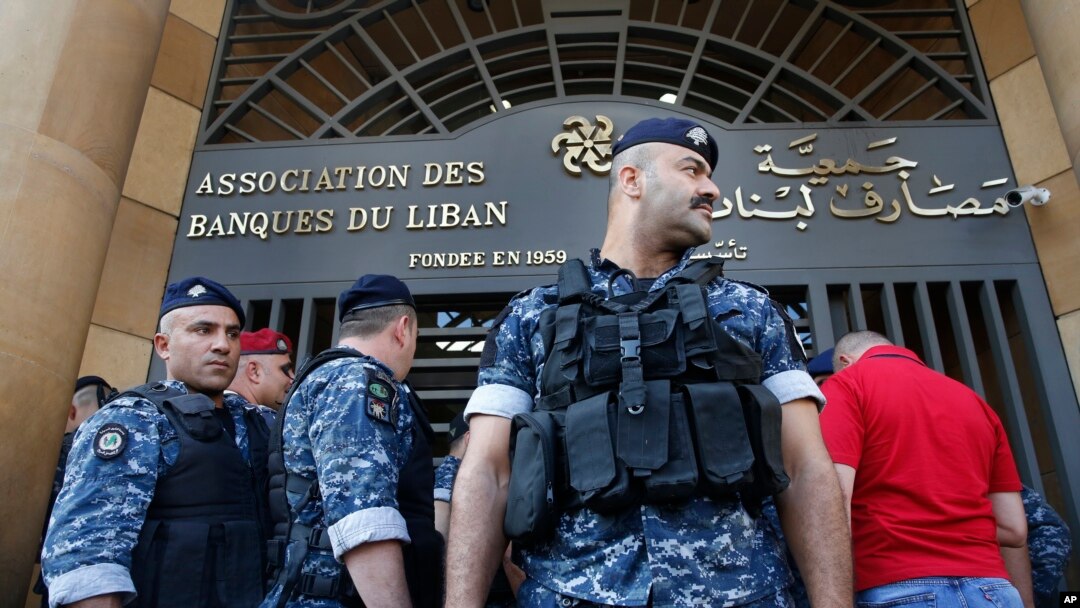 Police officers stand guard outside the building of the Lebanese Association of Banks after anti-government protesters locked the main entrance with a chain during ongoing protests against the banks and the government, in Beirut, Lebanon, Nov. 1, 2019.