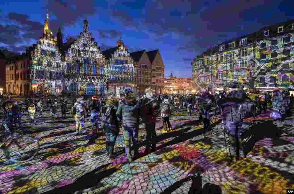 Visitors watch the light installation &quot;Frankfurt Fades&quot; by artist Philipp Geist presented during the Luminale Festival of Light at the Roemer square in Frankfurt am Main, western Germany, March 20, 2018.