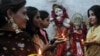 FILE - Pakistani Hindu women hold earthen oil lamps on the occasion of Diwali, in Lahore, on October 26, 2011. During Diwali, people honor Lakshmi, the Hindu goddess of wealth. 