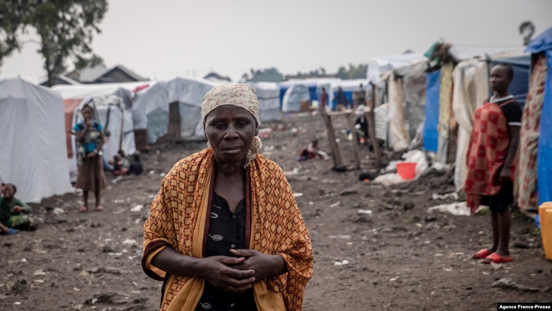 FILE - A woman walks at the Kayembe camp for dislaced persons, near Goma, Democratic Republic of Congo, Aug. 30, 2021.