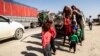 Syrian Arab and Kurdish civilians arrive to Tall Tamr town, in the Syrian northwestern Hasakeh province, after fleeing Turkish bombardment on the northeastern towns along the Turkish border, Oct. 10, 2019.