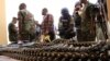 FILE - Journalists look at arms and ammunition which military commanders say they seized from Islamic fighters in Maiduguri, Nigeria.