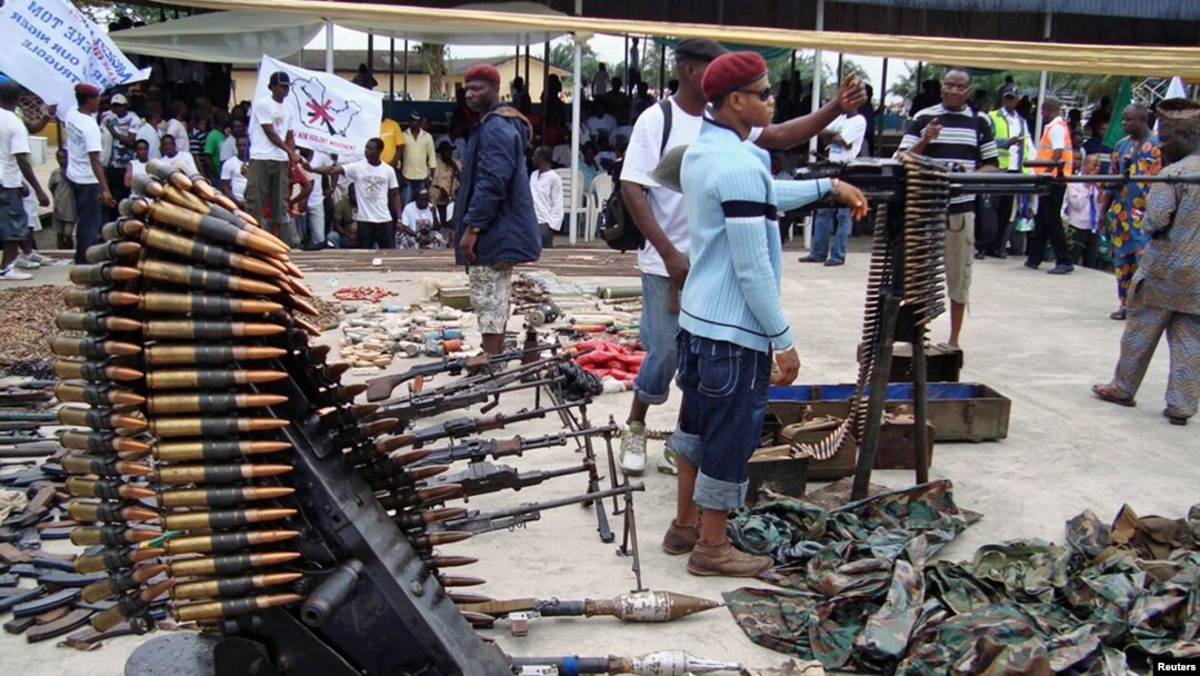 An October 2009 photo shows Nigerian militant youths displaying weapons surrendered by former militants at an arms collection center in the oil hub Port Harcourt.