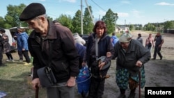 Мешканці Вовчанська та прилеглих сіл чекають на автобуси під час евакуації до Харкова через обстріли Росії, 10-го травня 2024 року. REUTERS/Vyacheslav Madiyevskyy
