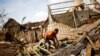 FILE - A man works on the destroyed house of Philibert Jean Claude Razananoro, in the aftermath of Cyclone Batsirai, in the town of Mananjary, Madagascar, Feb. 8, 2022. 