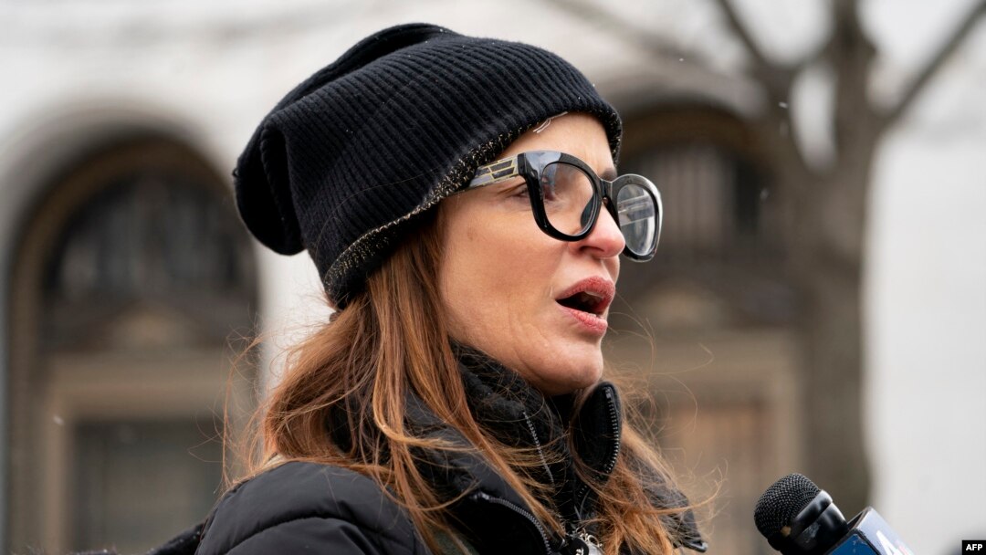 Patricia Oliver, wife of Manuel Oliver, speaks as her husband Manuel displays a banner calling for gun violence prevention from a construction crane near the White House on Feb.14, 2022. Oliver's son Joaquin Oliver was killed in the Parkland School shooting.